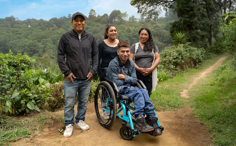 A family receiving a wheelchair from Free Wheelchair Mission